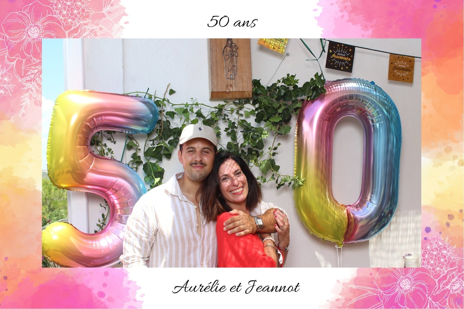 Duo souriant devant des ballons géants « 50 » au photobooth des 50 ans d’Aurélie et Jeannot